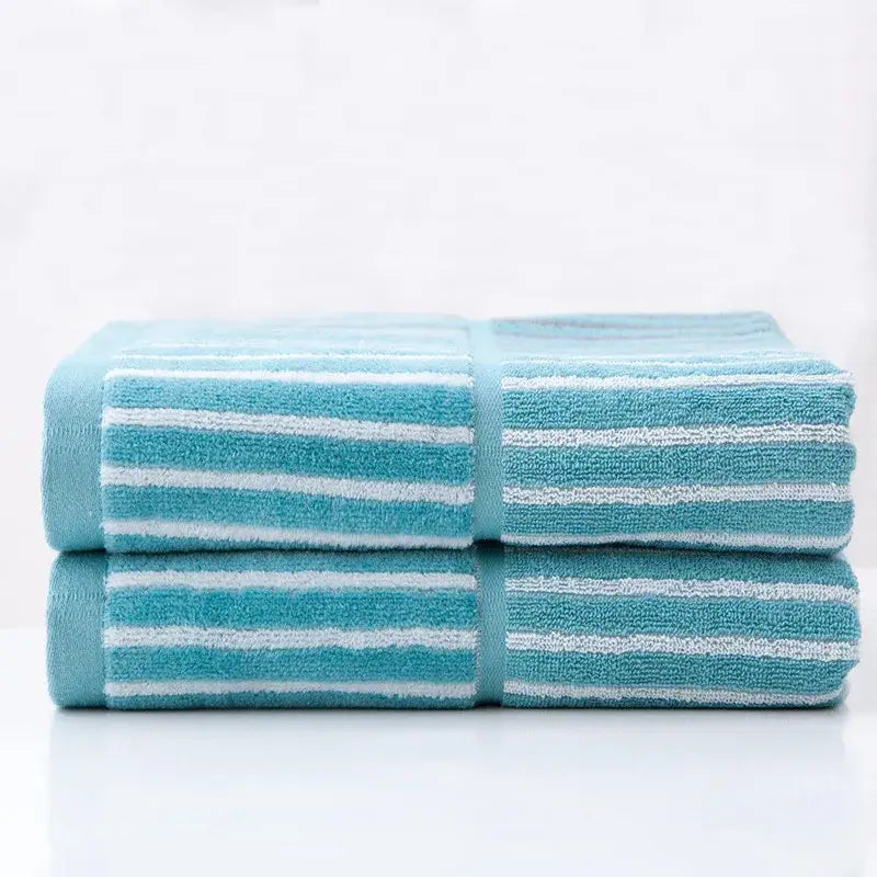 Two neatly folded british style turquoise and gray striped sports fitness towels with soft textured weave for gym use
