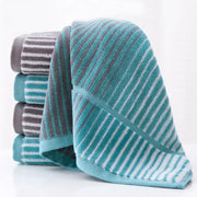 A soft plush turquoise and gray striped sports fitness towel with textured weave for gym accessory use