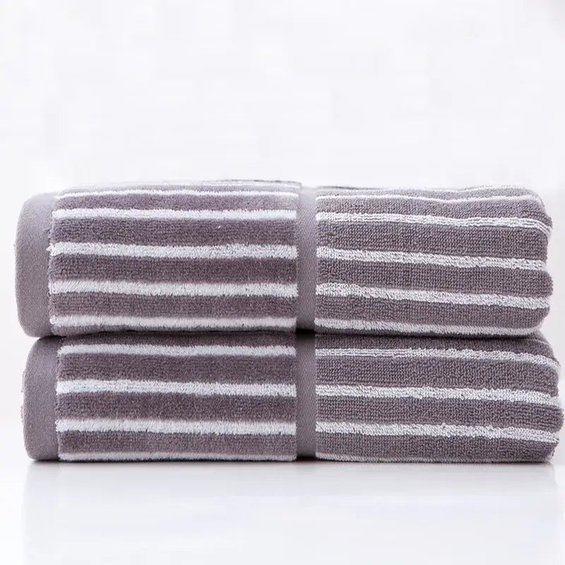 Stacked gray and white striped sports fitness towels with a soft textured weave for gym accessory use