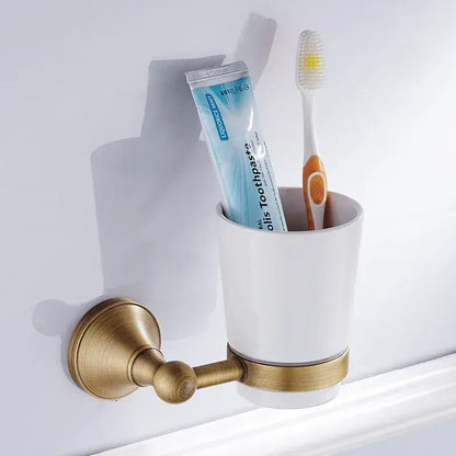 White ceramic toothbrush holder with brass metal bracket and accent band in decorbites bronze bathroom accessories set