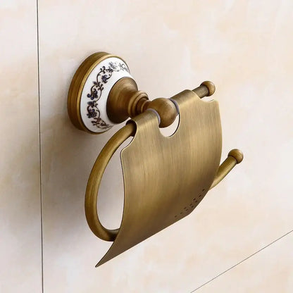 Antique brass toilet paper holder with ceramic base and black floral patterns in decorbites bronze bathroom hardware set