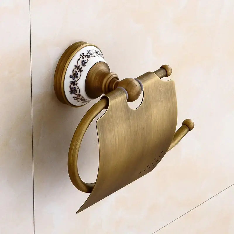 Antique brass toilet paper holder with ceramic base and black floral patterns in decorbites bronze bathroom hardware set