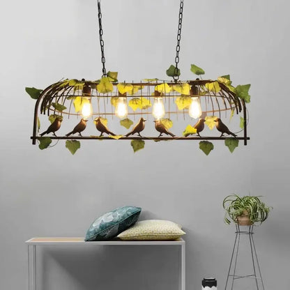 Bronze birdcage pendant lights with wrought iron bird-themed design, golden-brown birds, green leaves, and four bulbs suspended by black chains for dining room decorbites pendant lights
