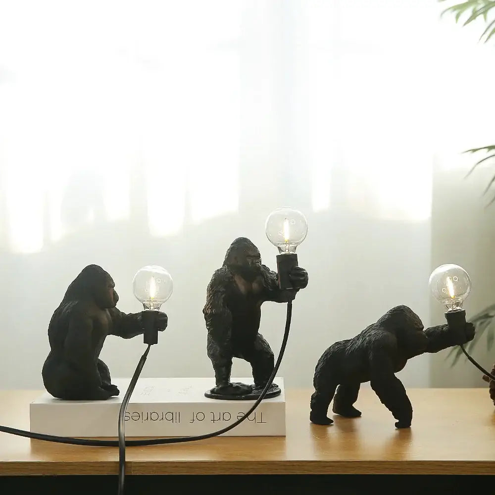 Three bronze king kong gorilla table lamps in black holding lit bulbs for bedroom night light decorbites king kong design