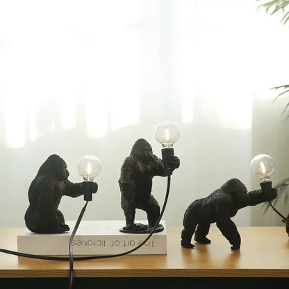 Three bronze king kong gorilla table lamps in black holding lit bulbs for bedroom night light decorbites king kong design