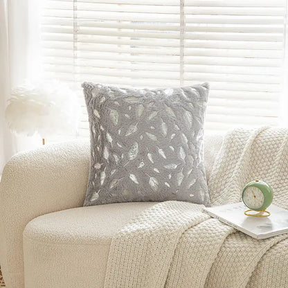 Gray plush throw pillow with textured leafy pattern in lighter gray and silver tones for bronzed feather style decor
