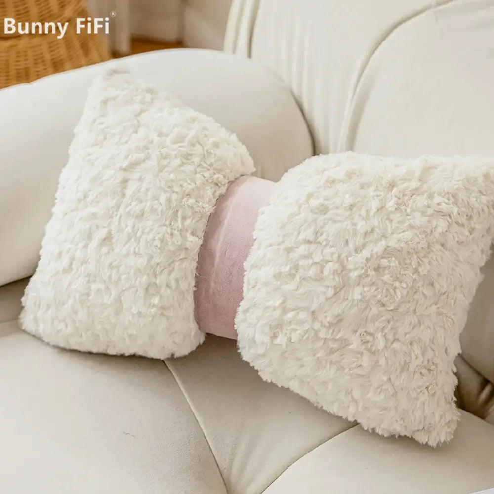 Cream-colored sheepskin-style neck pillow with soft pink band paired with brown and white geometric embroidery plush cushion cover