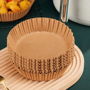 Stack of brown non-stick barbecue paper baking cups with fluted edges for kitchen cooking and barbecue use