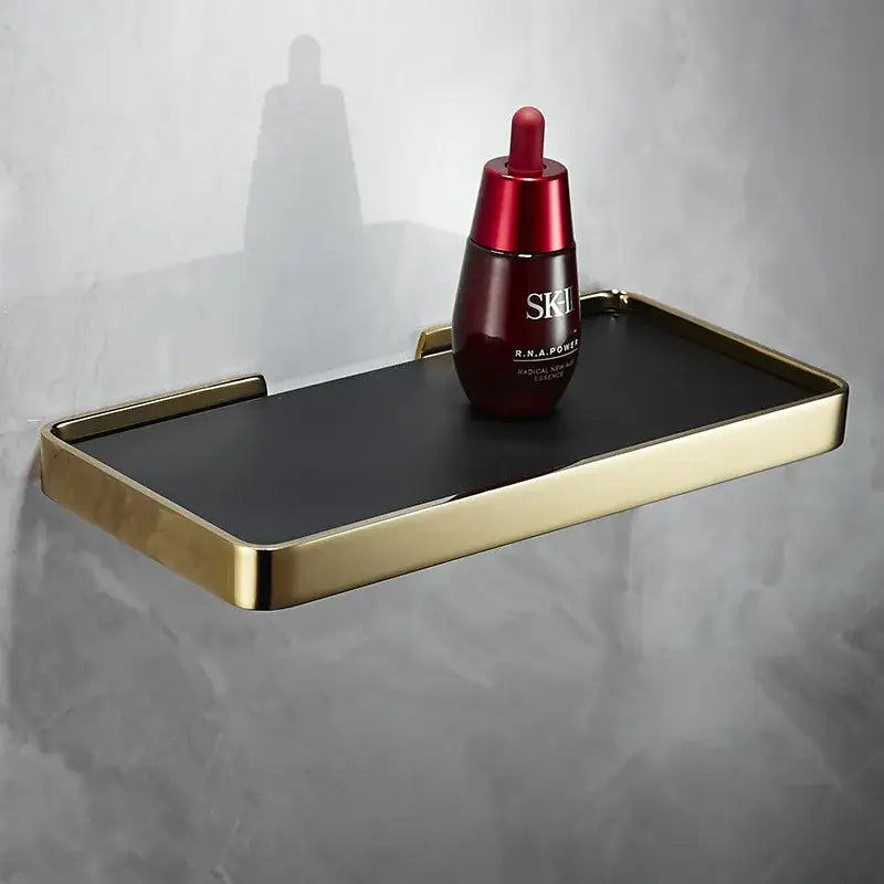 Brushed gold and black corner shelf holding red SK-II facial essence bottle for brushed gold bathroom storage decorbites