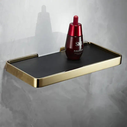 Gold-framed black rectangular corner shelf holding red sk-ii facial essence by decorbites brushed gold bathroom organizer