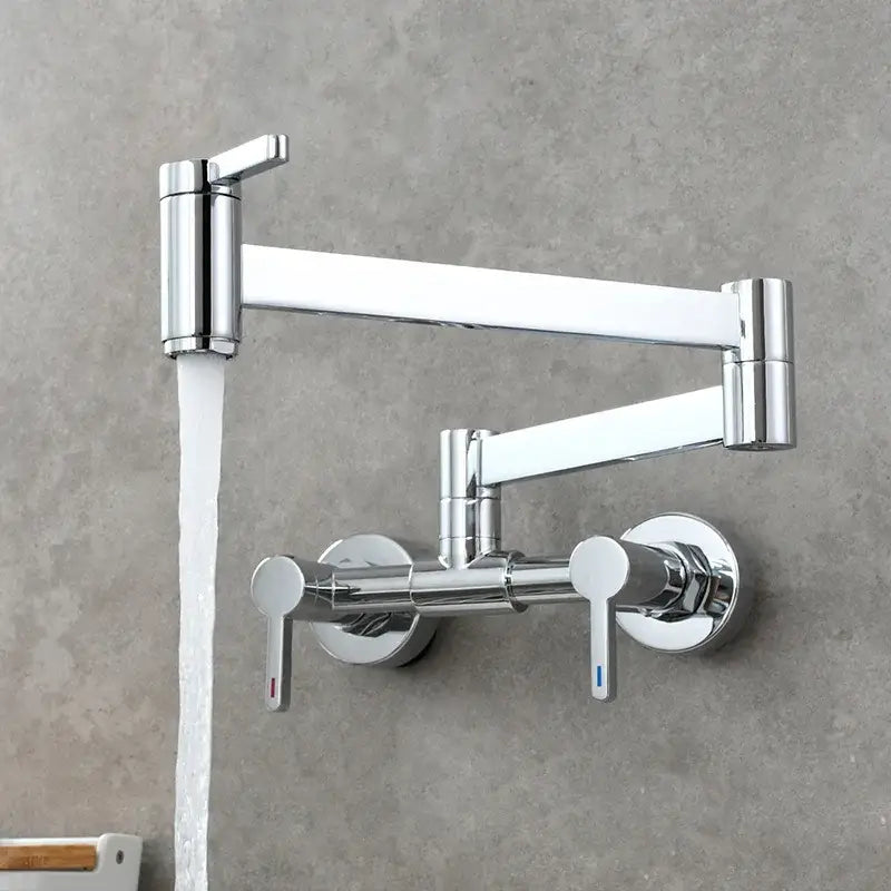 Chrome finished kitchen faucet with articulated design and dual handles paired with brushed gold foldable spout