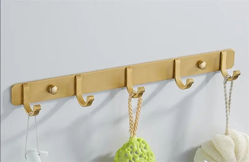 Brushed gold metal wall-mounted robe hooks rack with five hooks and round decorative knobs by decorbites brushed gold