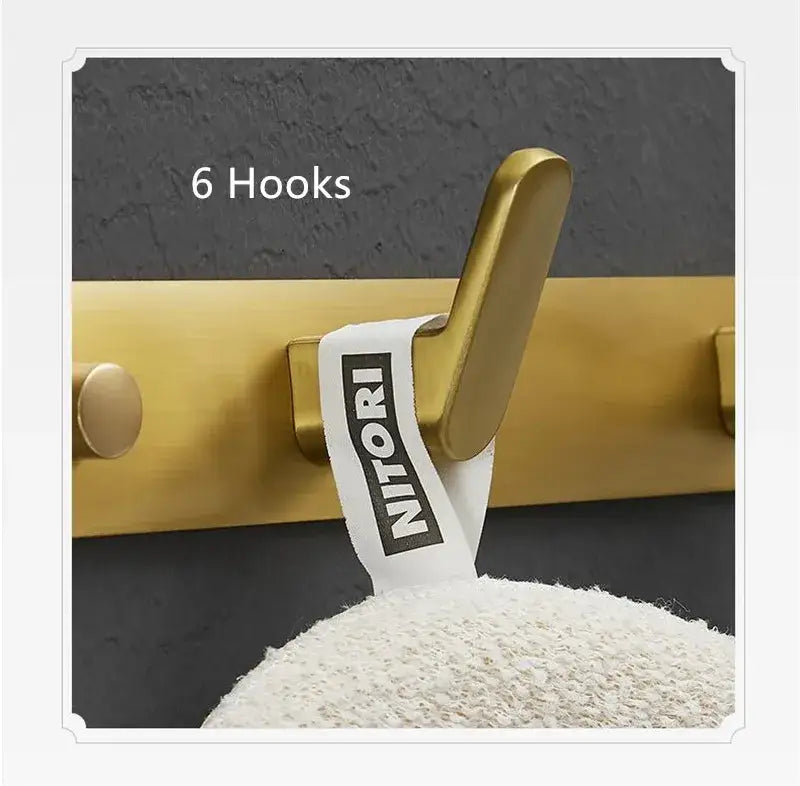 Brushed gold robe hook with sleek modern metal design and Nitori brand label for bathroom and kitchen decorbites brushed gold
