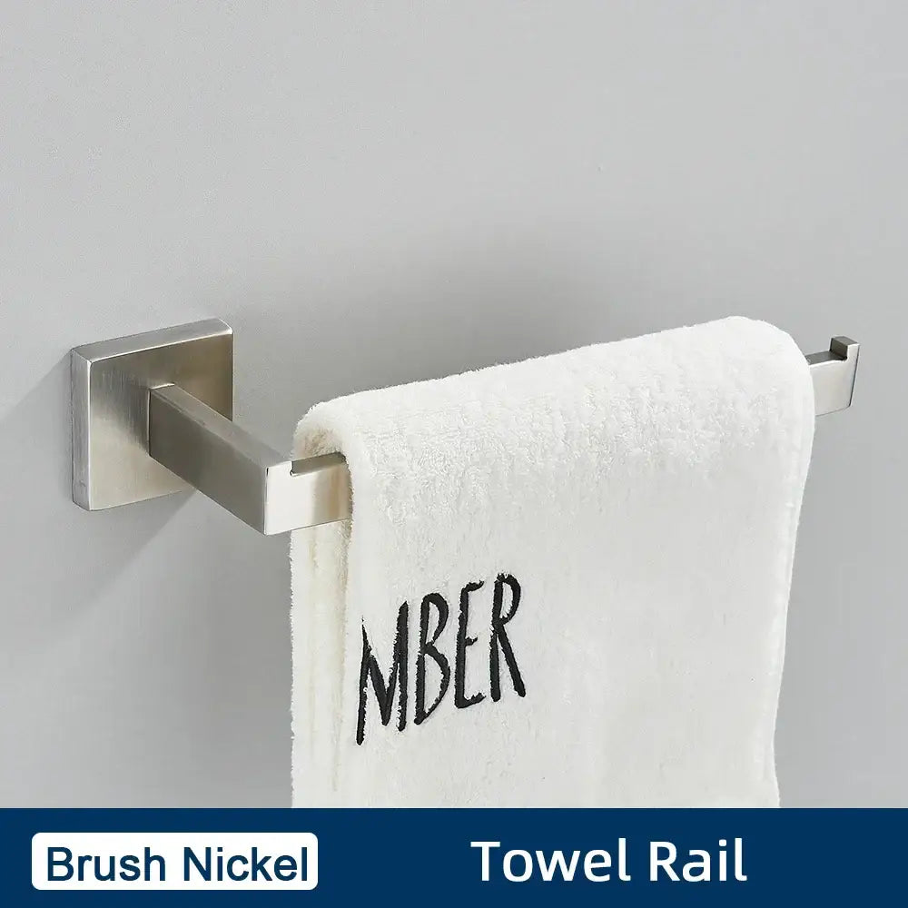 Brushed gold stainless steel bathroom accessories set featuring a brush nickel towel rail with modern design holding a white towel embroidered mber