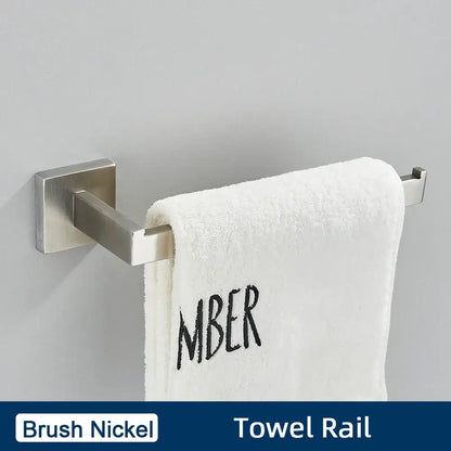Brushed gold stainless steel bathroom accessories set featuring a brush nickel towel rail with modern design holding a white towel embroidered mber