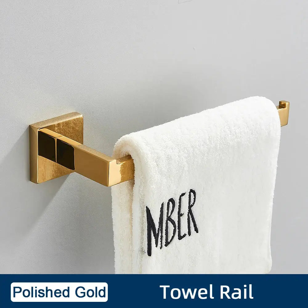 Polished gold towel rail from brushed gold stainless steel bathroom accessories set holding white towel with black embroidery