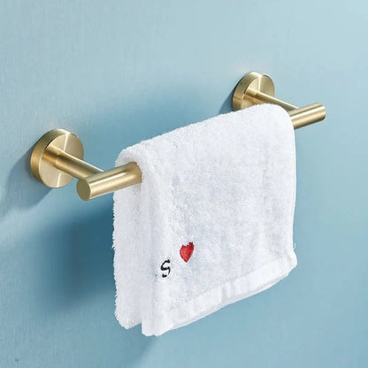 Gold-toned brushed stainless steel double towel rack holding white terry cloth towel with embroidered red heart for bathroom accessories set
