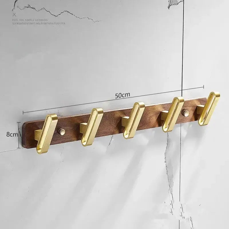 Brushed gold wood and aluminum robe hook towel hanger with gold-toned metal hooks mounted on a dark wood plank 50cm long