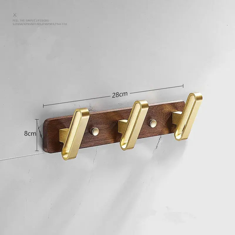 Brushed gold wood and aluminum robe hook towel hanger with gold-toned metal hooks mounted on dark wood plank