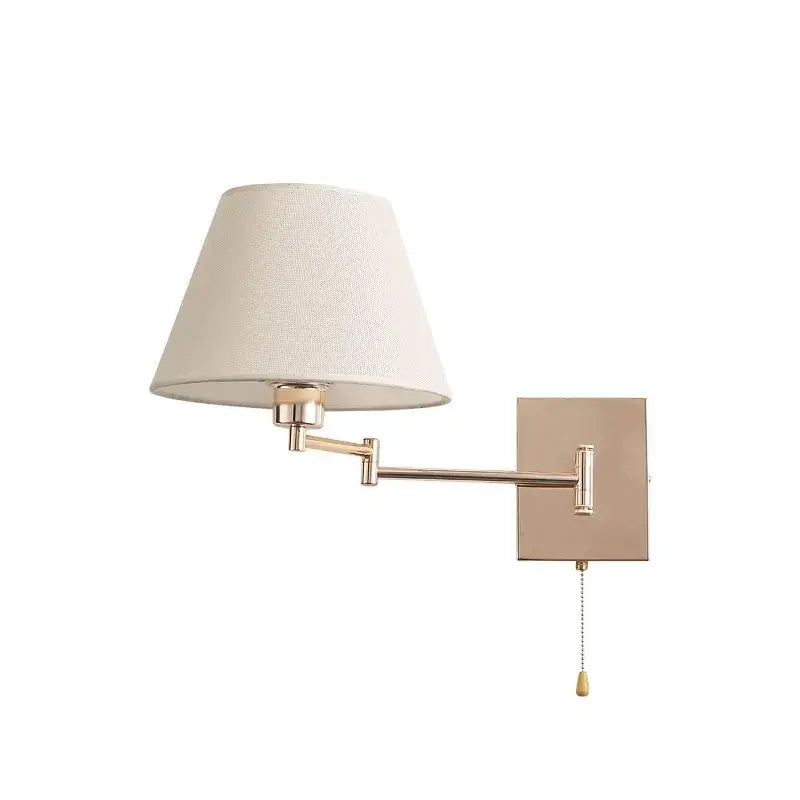 A sleek adjustable rocker arm wall lamp in matte brass with a cream fabric shade for bedroom lighting