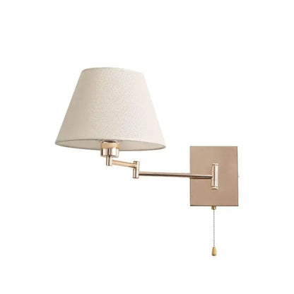 A sleek adjustable rocker arm wall lamp in matte brass with a cream fabric shade for bedroom lighting