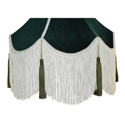 Dark green velvet lampshade with white fringe and matching tassels complementing burgundy wine red velvet decor