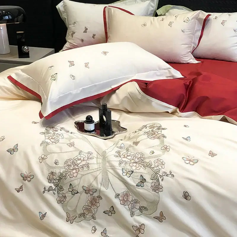 Cream-colored satin bedding set with intricate butterfly flowers embroidery in soft gray pink and beige by decorbites