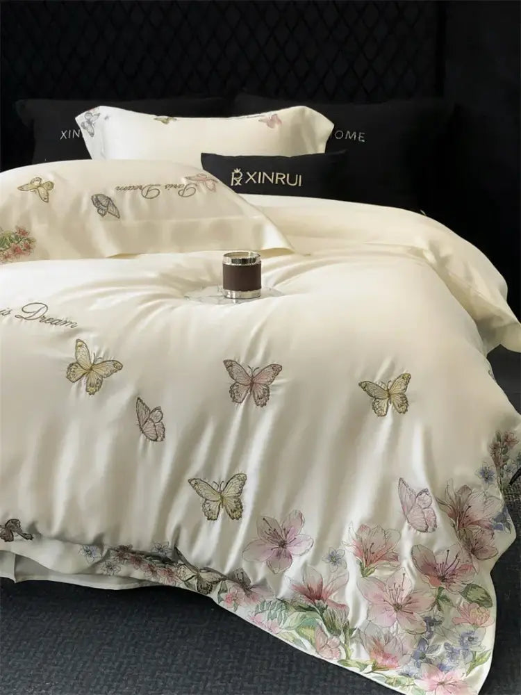 Cream-colored satin duvet cover with butterfly flowers embroidery in soft pastels for elegant bedding set decorbites