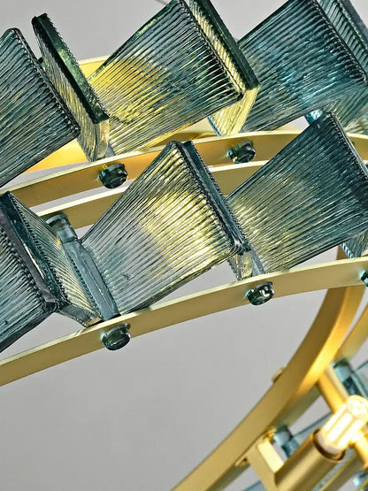 A decorbites butterfly glass chandelier with translucent teal ridged panels on a polished brass frame for dining room lighting