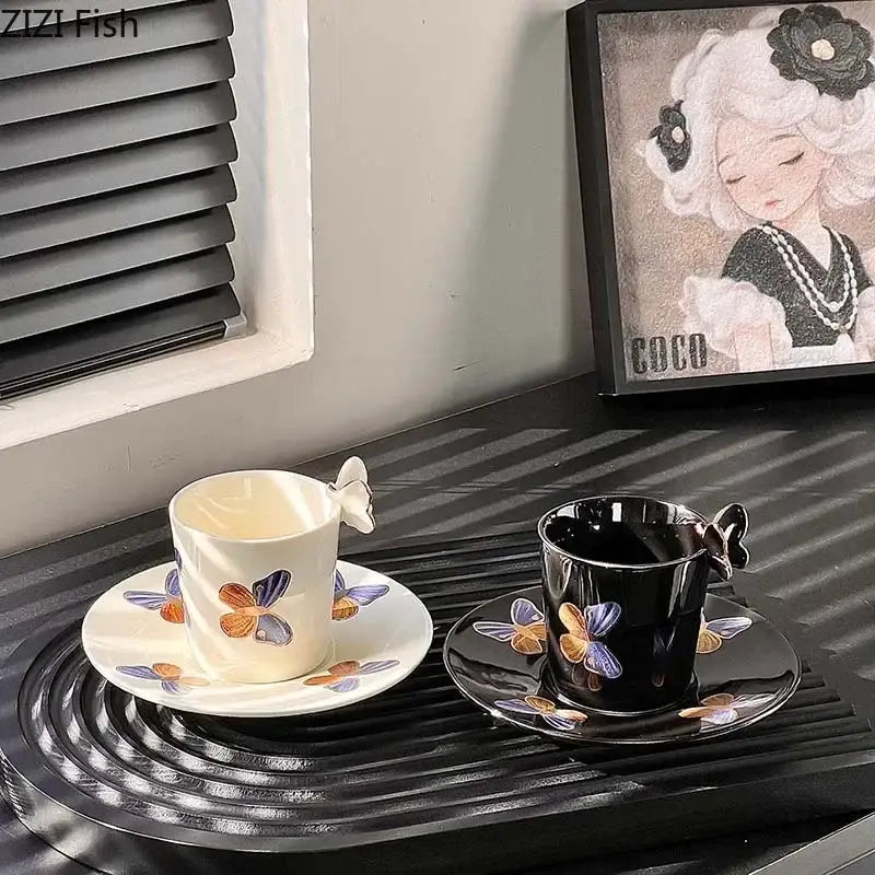 A pair of decorbites butterfly pattern ceramic cup and saucer set in cream and black with colorful butterfly details