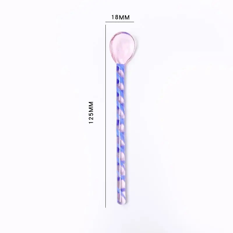 A translucent pink and blue twisted glass stirring spoon with a rounded glossy head from decorbites colorful glass set