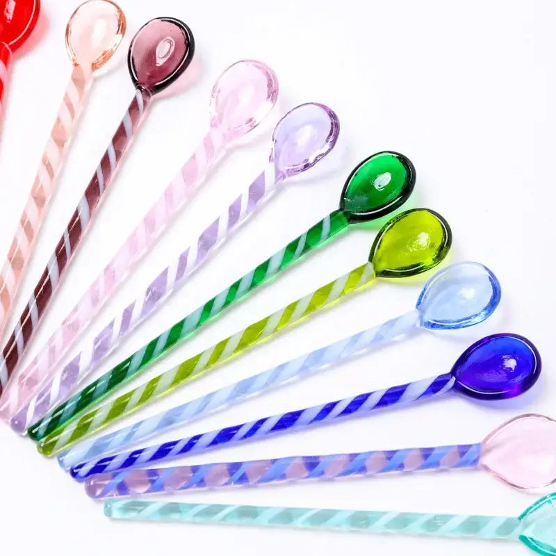 A set of colorful glass stirring spoons with twisted striped handles and teardrop heads for decorbites colorful glass decor
