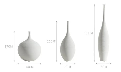 Three minimalist white ceramic vases of varying heights and slender shapes for zen home decoration and living room centerpiece