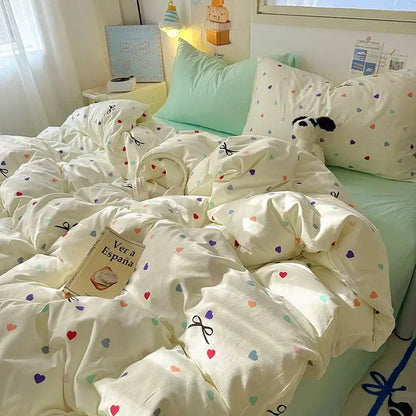 Cream-colored satin quilt cover set with playful multicolored hearts and black bow details for bedroom bedding