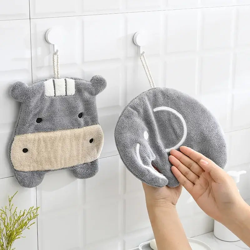 Gray plush hippo-shaped hand towel with beige snout and white embroidered details from decorbites cartoon animals coral collection