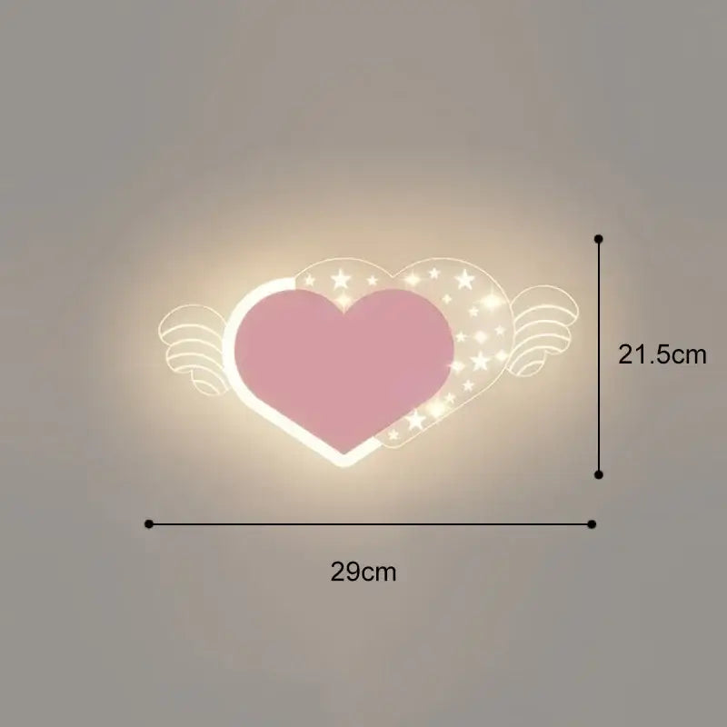 Pink heart-shaped wall lamp with angel wings and star details emitting warm glow in cartoon wall lamp style