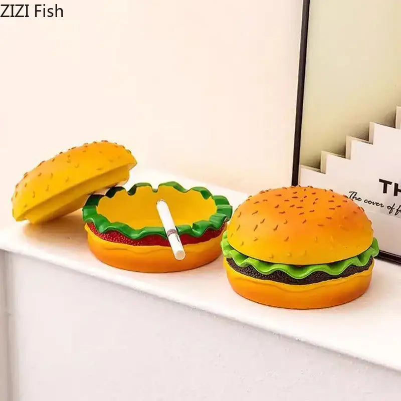 Yellow and green resin cartoon burger ashtray with lid open showing cigarette interior for office table decor