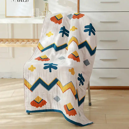 A white cotton gauze bath towel with playful orange yellow and teal geometric shapes for bedroom and nursery decorbites cotton gauze