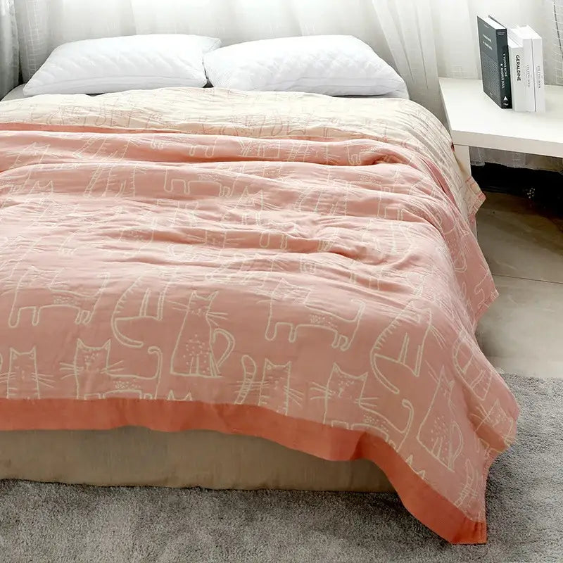 A soft peach cartoon cat bamboo cotton throw blanket with delicate white cat pattern for cream bedroom decorbites decor
