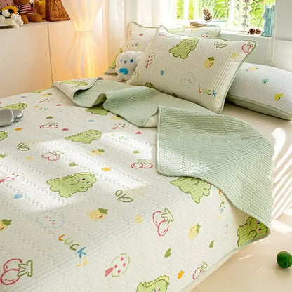 A soft mint green cotton quilted bed cover set featuring cartoon dinosaurs cherries and colorful luck letters
