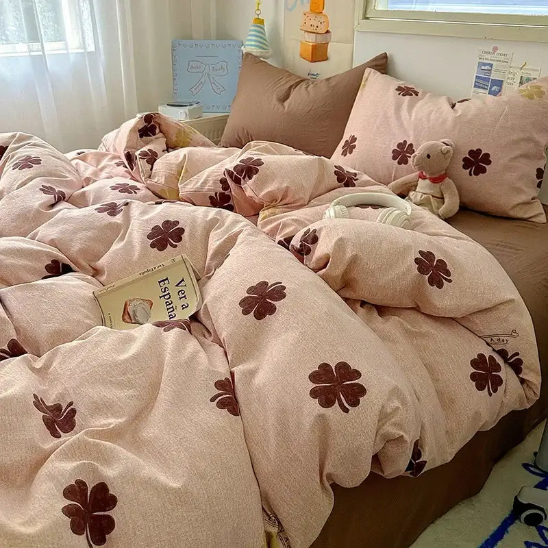 Pink four-leaf clover patterned duvet cover set with brown embroidered leaves paired with cartoon dog and cupcake fitted sheet set