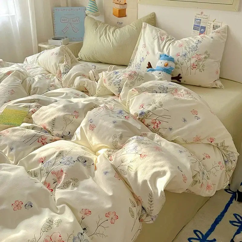 Cream-colored fitted sheet set featuring soft cotton fabric with delicate pink, blue, and green floral blossoms