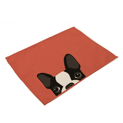 A rectangular orange cotton linen dining table mat with a cartoon black and white boston terrier design peek