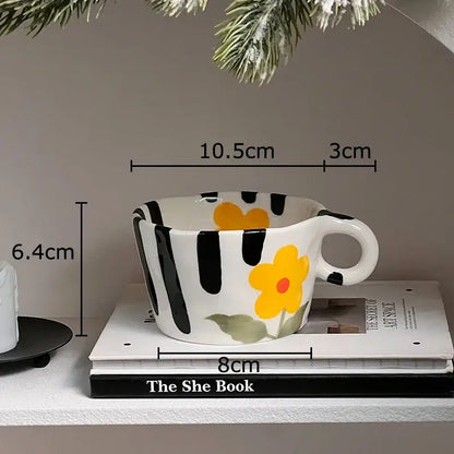 A white ceramic cartoon pattern ceramic coffee mug with bold black stripes and a yellow flower for kitchen decorbites