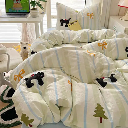 Cozy cream and blue cartoon style cotton bedding sets with black cat appliqués, yellow bows, and green pine tree motifs