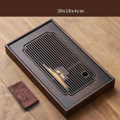 Dark brown bamboo tea tray with carved golden deer design and slatted drainage board for dining room use
