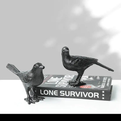Black iron bird decoration with detailed feather texture and sturdy legs positioned on a book for living room display