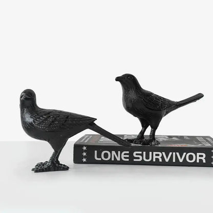 Two matte black cast iron bird figurines with detailed feathers and elongated tails for elegant living room decoration