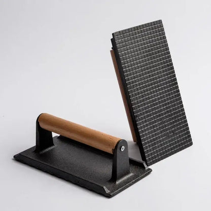 Black cast iron steak press plate with wooden handle and textured grilling surface for kitchen meat tool use