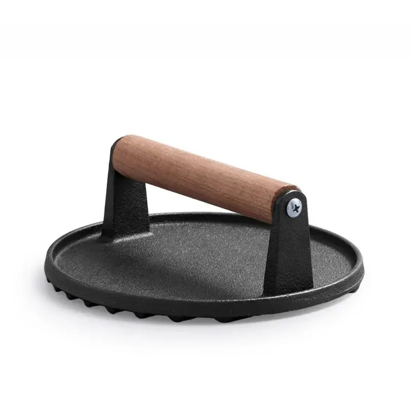 Black cast iron steak press plate with light brown wooden handle kitchen tool for even cooking and grilling